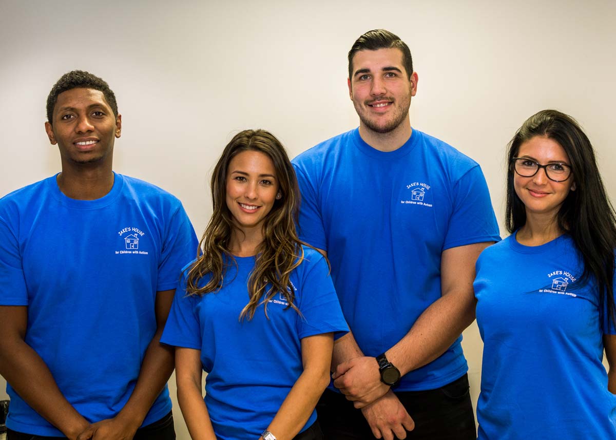 a team of four people in blue tshirts with the jakes house logo