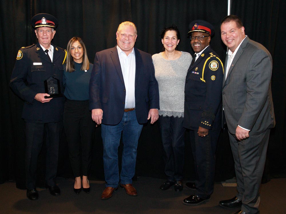 group photo of police officers event guests and doug ford