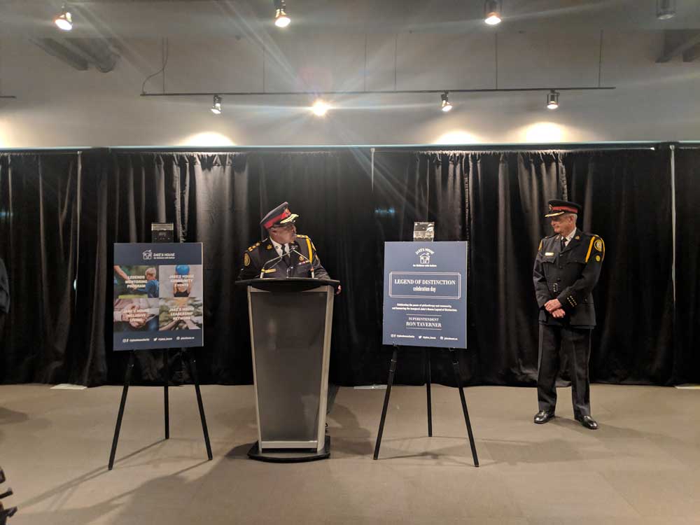 police officer standing at podium during jake's house event