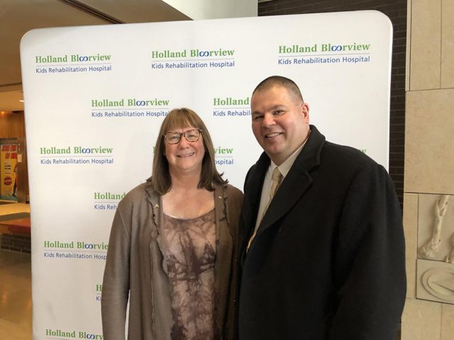 two smiling people posing at a press release