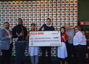 a group of people posing with a giant-sized cheque for a charity donation
