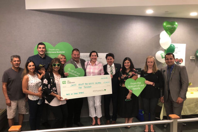 a group of people posing with a giant-sized cheque for a charity donation