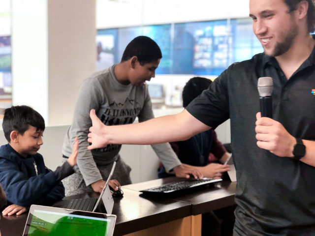 a man with a microphone high fives a kid at a Minecraft event