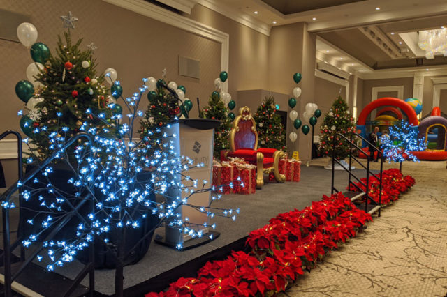 christmas event setup with festive chair for Santa and Christmas trees with lights